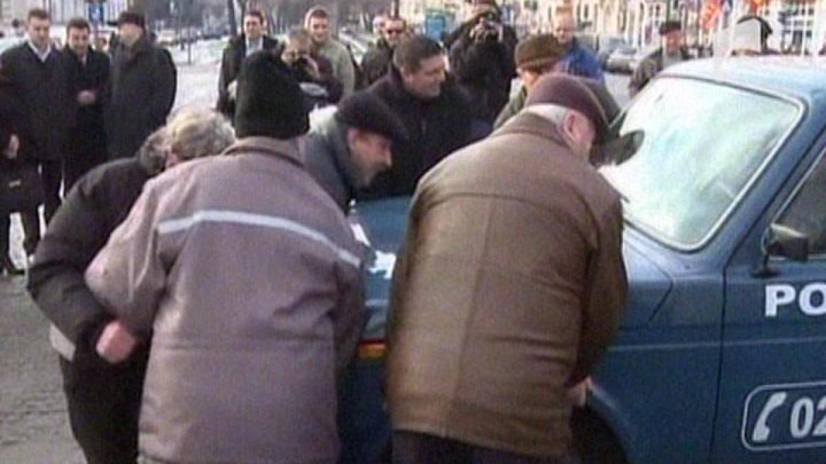 Scandal la Arad: Revoluţionarii au mutat o maşină de poliţie care bloca înălţarea drapelului