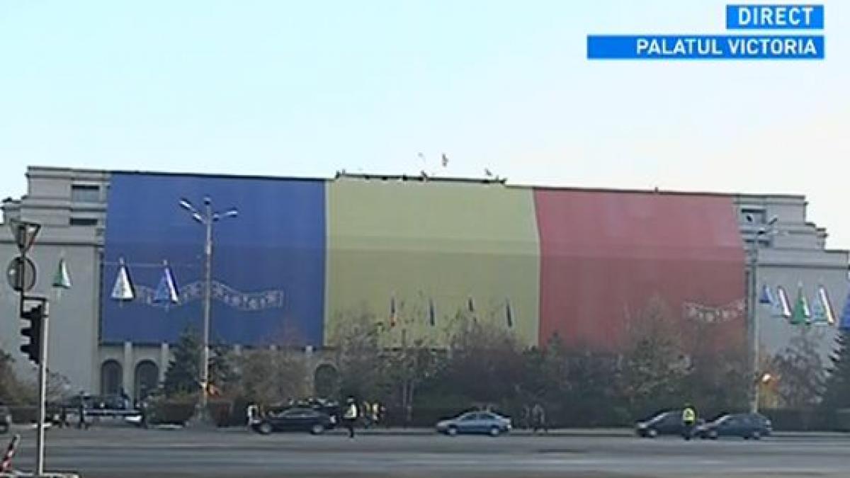 Tricolor uriaş descoperit pe frontispiciul clădirii Palatului Victoria, de Ziua Naţională a României