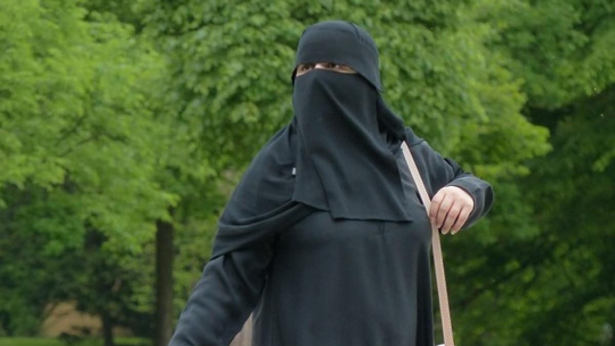 O femeie îmbrăcată în haine islamice, deranjată de ce a văzut în vitrina unui magazin. Ce a urmat apoi