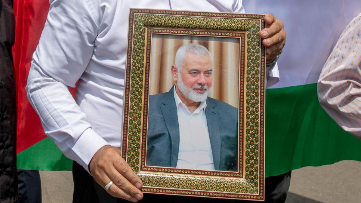 un barbat tine in mana o fotografie cu  Ismail Haniyeh