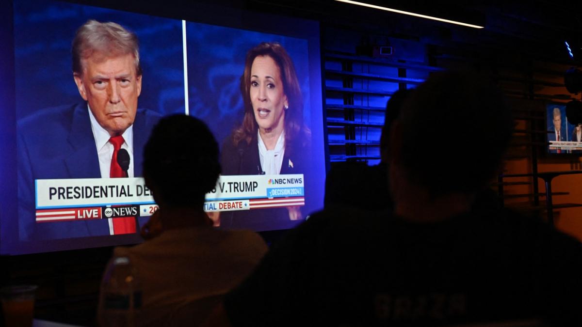 oameni se uita la tv la dezbaterea trump-harris