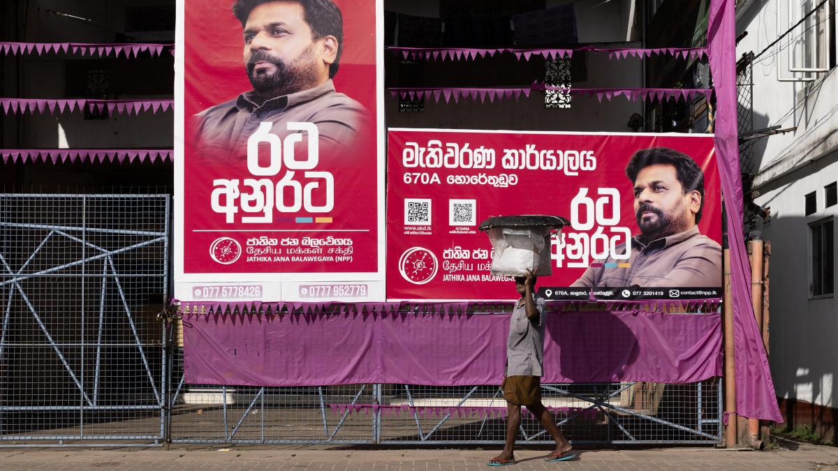 Om din Sri Lanka cu o galeata de peste in cap trece pe langa bannere de campanie prezidentiala.