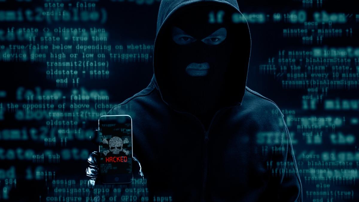 hacker cu telefon in mana atac cibernetic