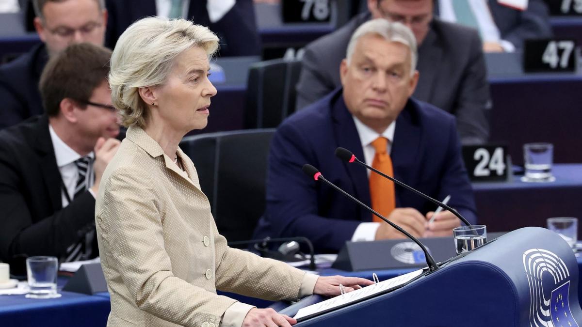 Ursula von der Leyen vorbeste de la pupitrul PE in timp ce, pe fundal, Viktor Orban o priveste.