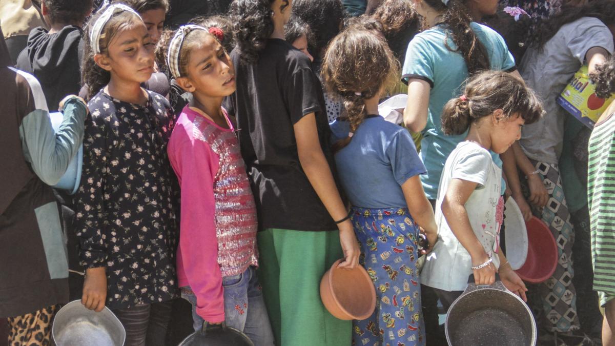 Copii cu castroane in mana la coada la ajutor umanitar in Gaza