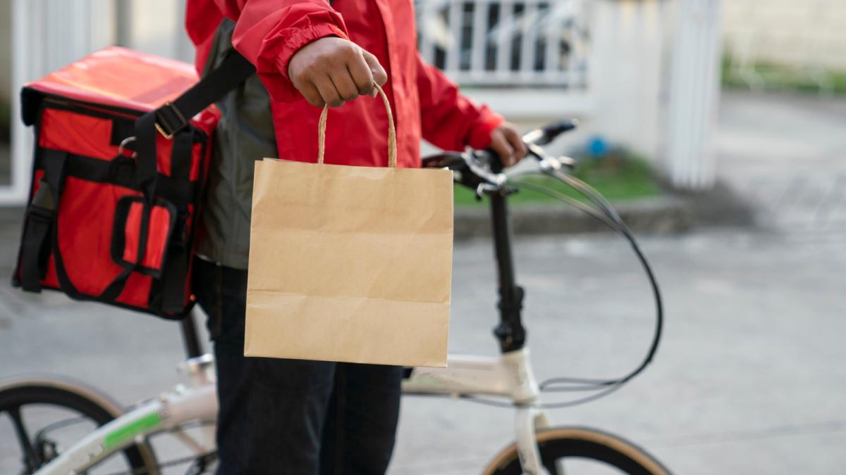 curier langa o bicicleta care livreaza mancare