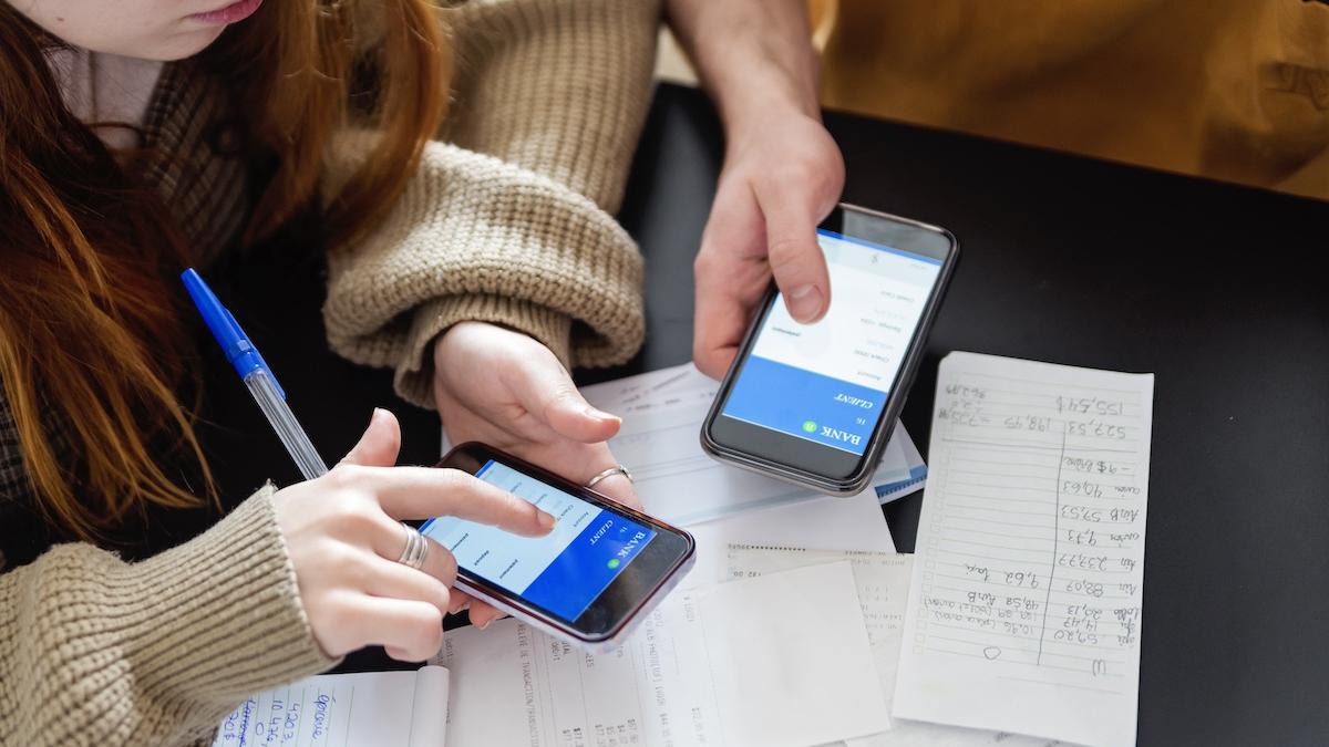 tineri cu telefoanele in mana platind facturi