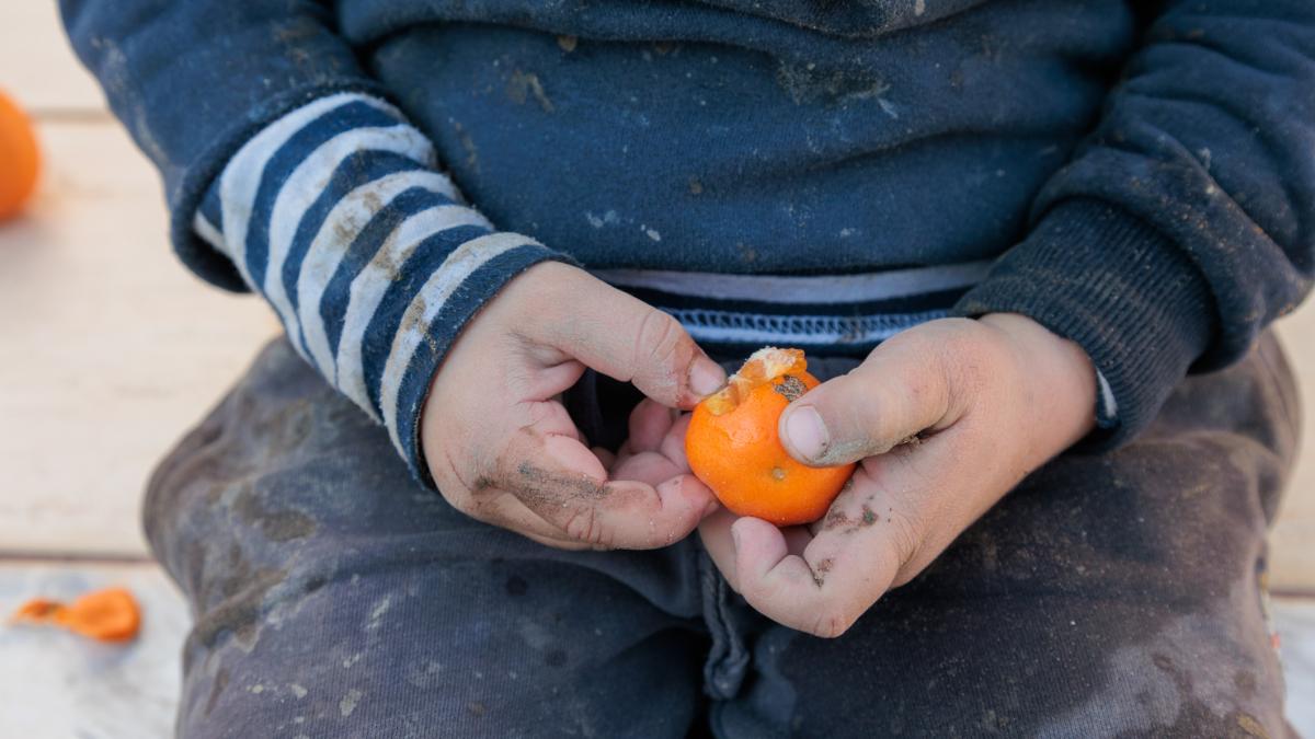 copil care desface o mandarina