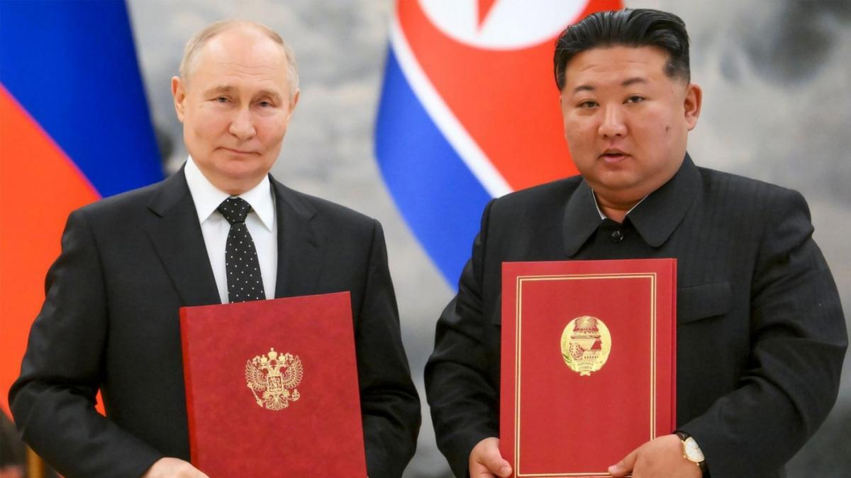 Kim și Putin pozează cu două documente cu copertă roșie