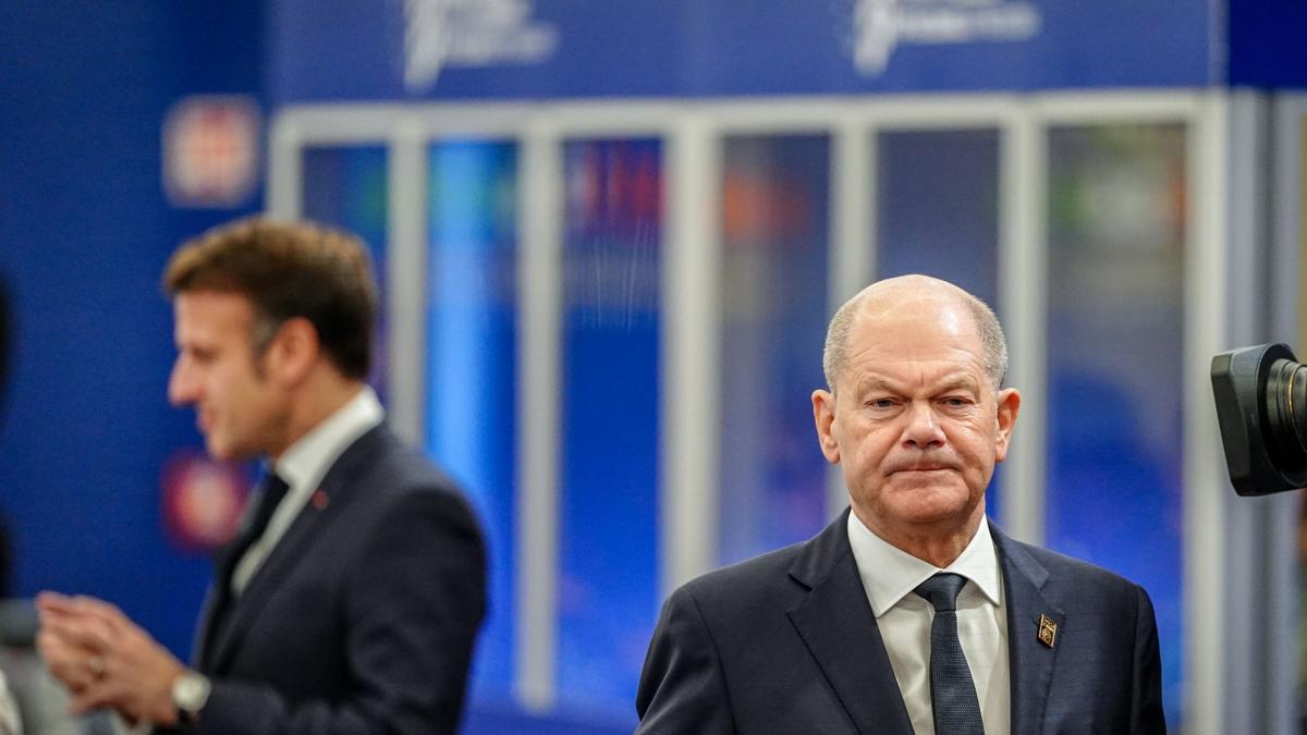 Olaf Scholz în față și Emmanuel Macron pe fundal.