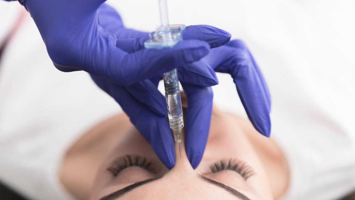 Un medic estetician face o injectie unei paciente