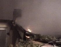 Trei acoperişuri au ars după ce o femeie şi-a dat foc la casă (VIDEO)