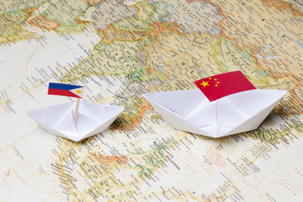 harta cu doua barci din hartie si steagurile chinei si filipinelor