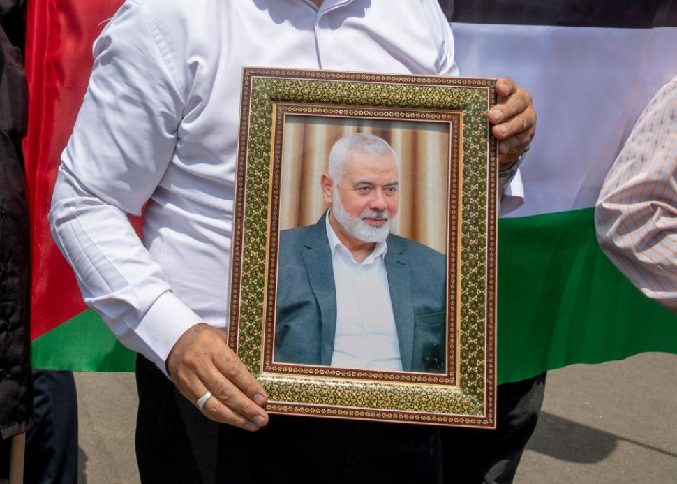 un barbat tine in mana o fotografie cu  Ismail Haniyeh