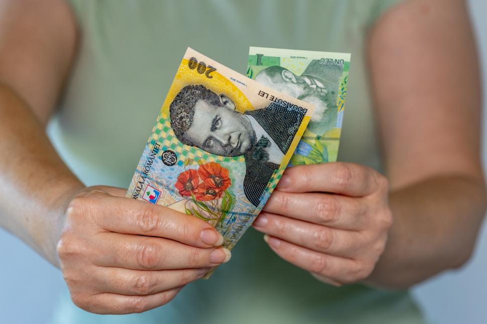 femeie cu doua bancnote in mana
