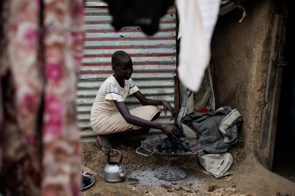 O fat? preg?te?te c?rbuni pentru foc în Sudan.