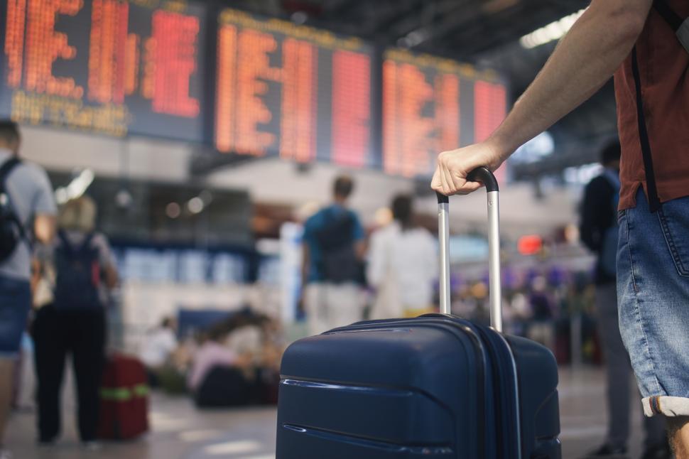 barbat cu bagaj in aeroport