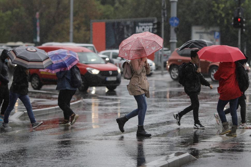 oameni cu umbrela pe strada in ploaie