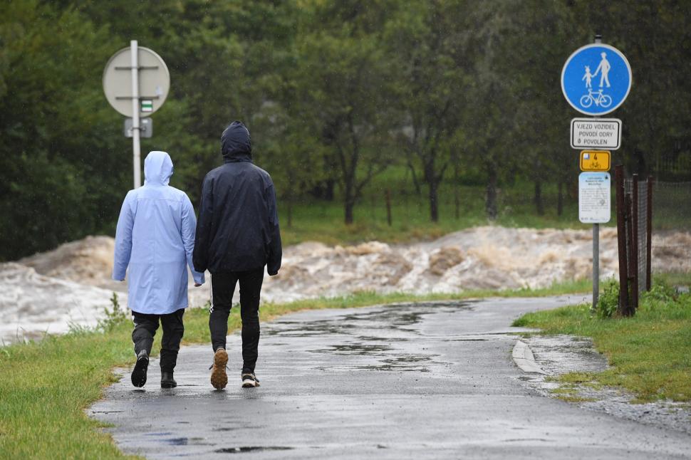 oameni în geci în fa?a unui rau involburat