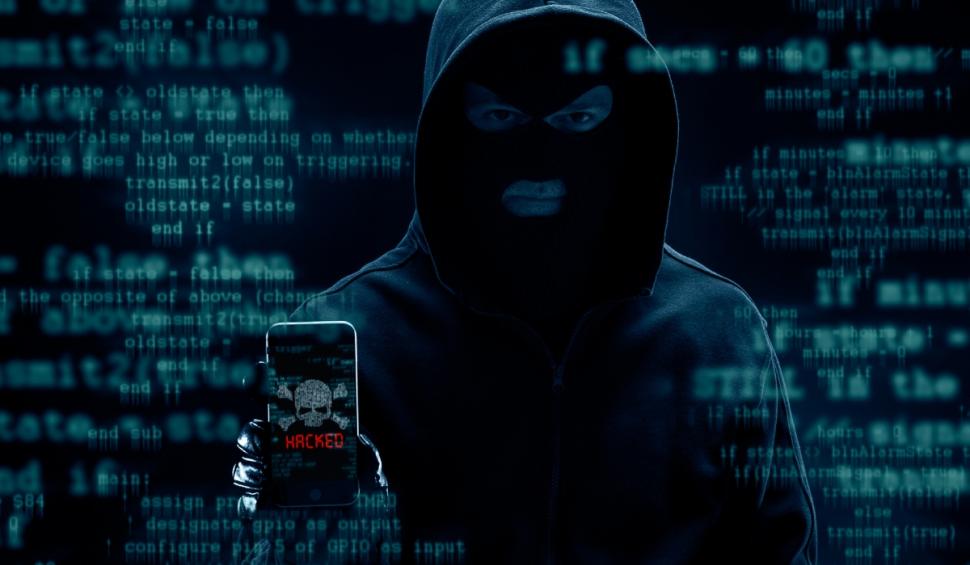 hacker cu telefon in mana atac cibernetic