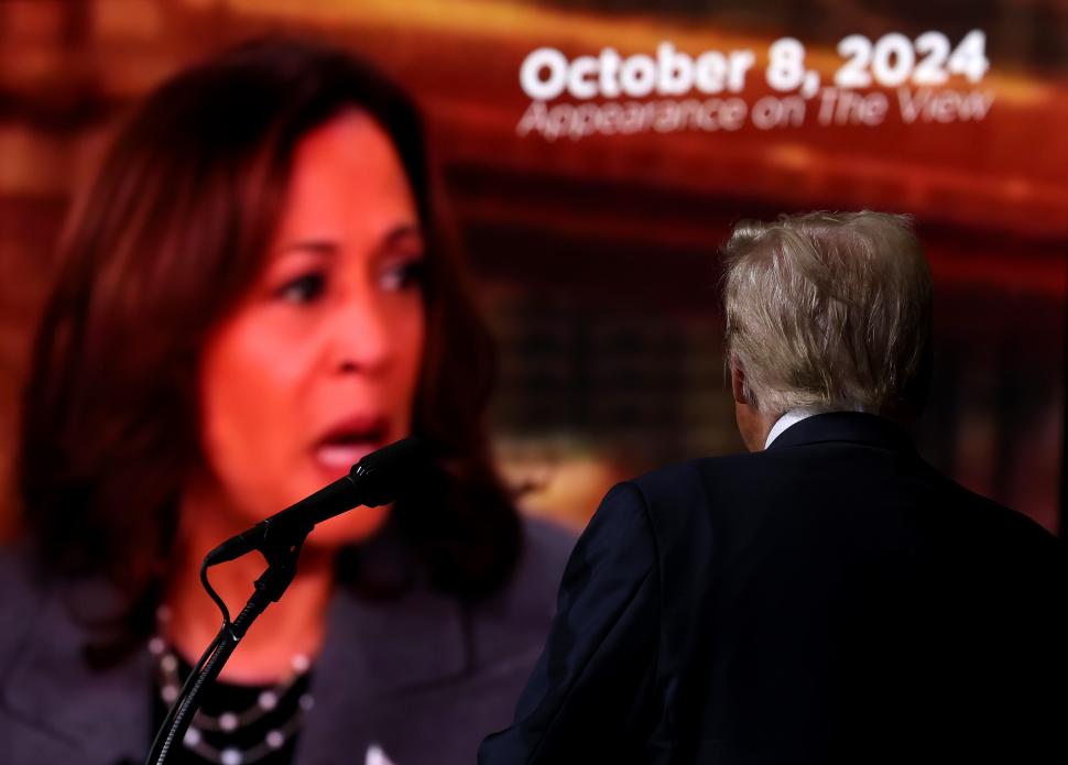 Donald Trump priveste spre un ecran in care apare Kamala Harris