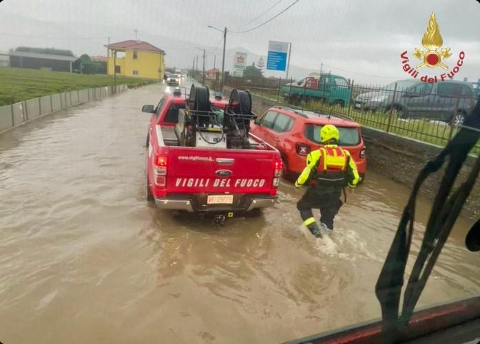 Un salvator merge prin apa mare spre o masina rosie