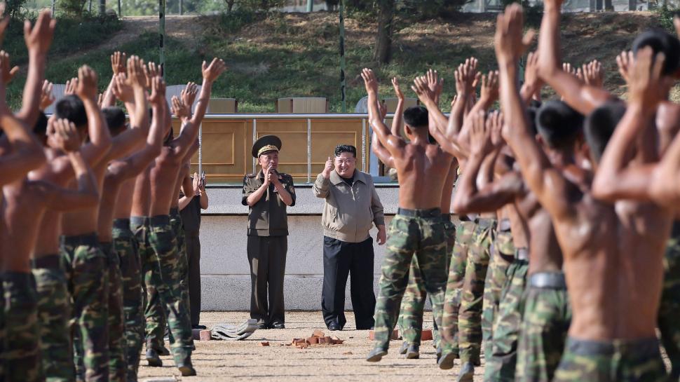 Soldaţi nord-coreeni cu mâinile ridicate în faţa lui Kim Jong-un.