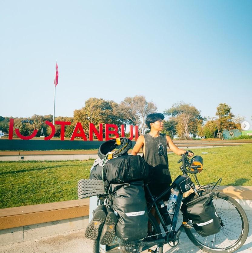 Un barbat japonez cu mai multe bagaje si o bicicleta