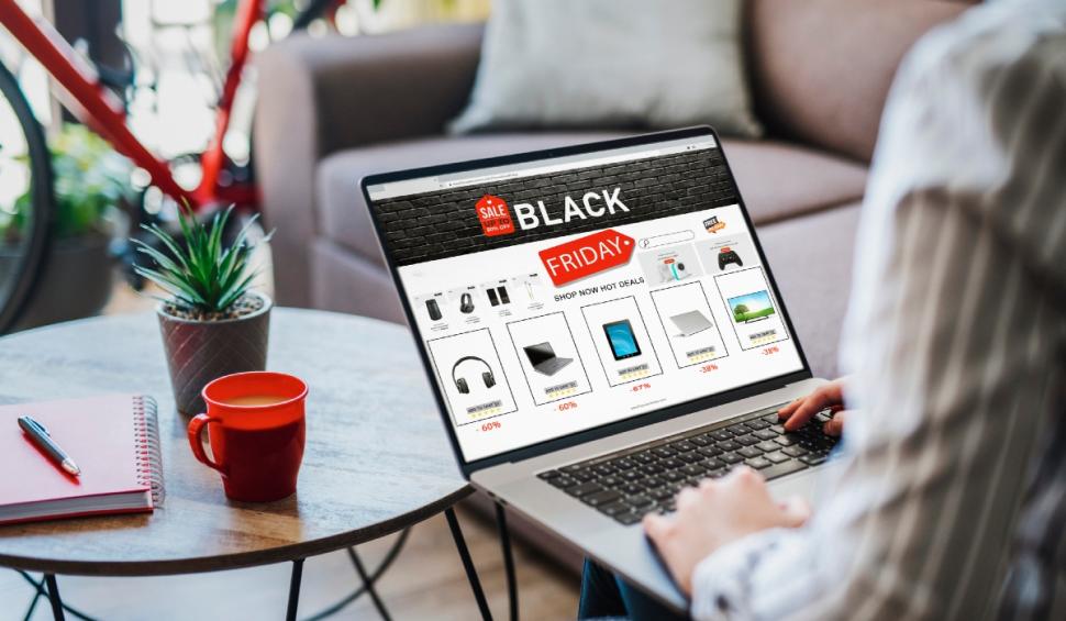 femeie care comanda online pe laptop produse de black friday