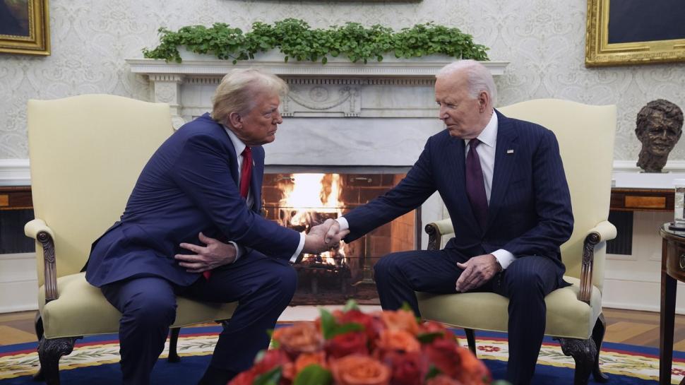 Donald Trump îi strânge mâna lui Joe Biden.