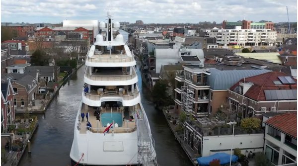 Imagini impresionante cu un super iaht care se strecoară prin canalele înguste din Olanda