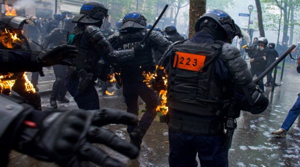 Momentul în care polițiștii francezi sunt incendiați de protestatarii care se opun reformei pensiilor