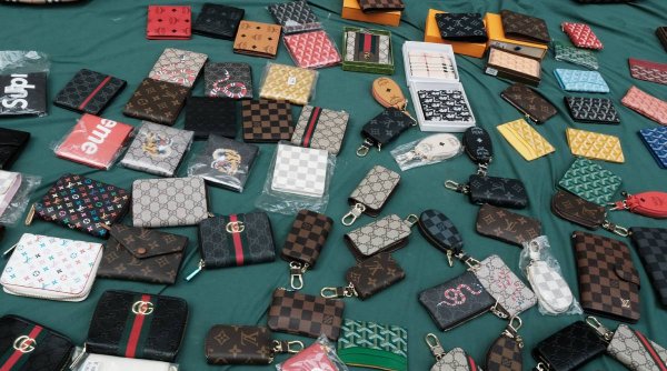 Sute de produse de lux, contrafăcute, vândute de un magazin online, din București. Vânzătorii s-au trezit cu Poliția la ușă